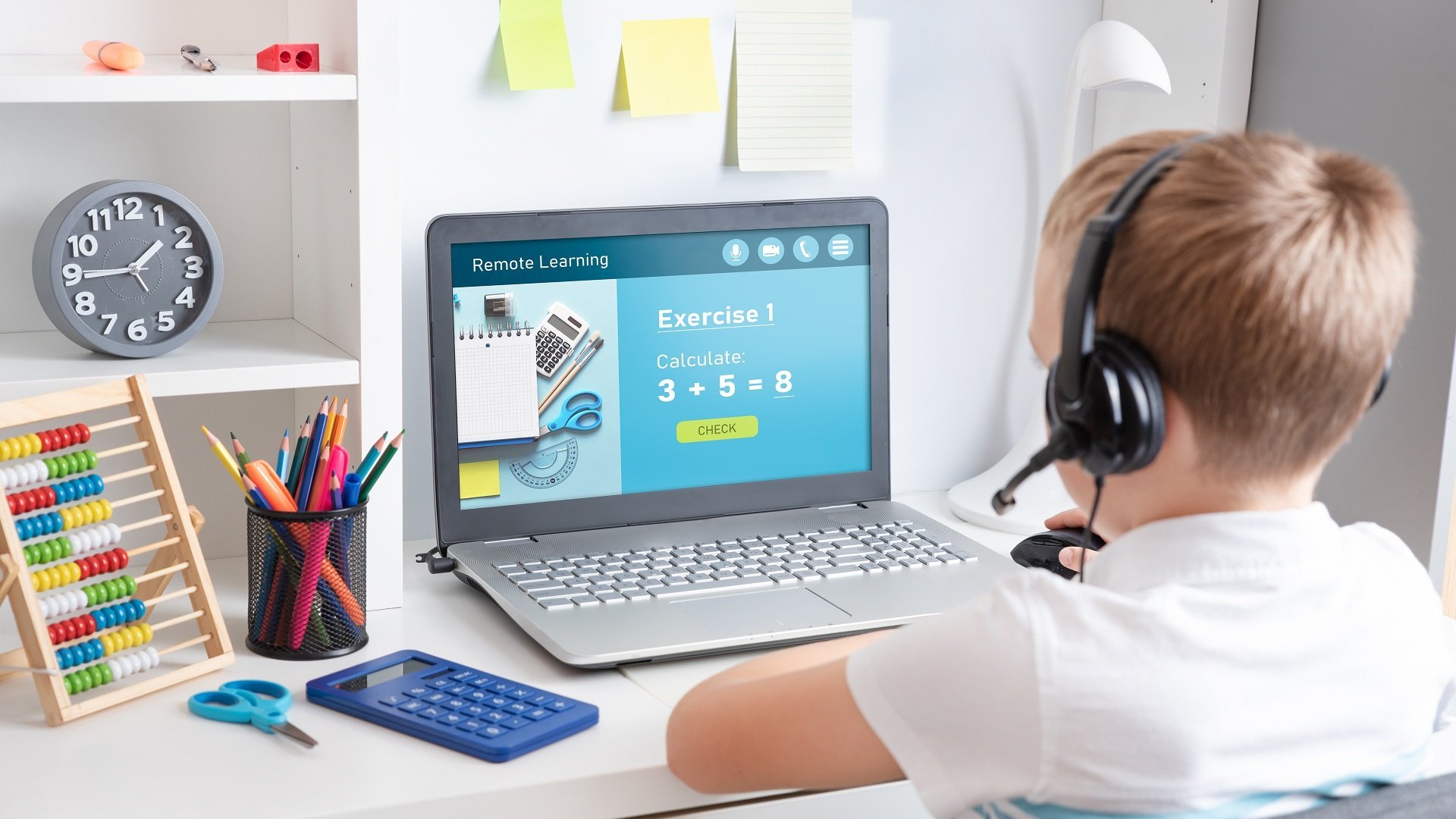 Ein Junge sitzt konzentriert in seinem Kinderzimmer vor einem Laptop. Auf dem Bildschirm ist das Wort "Remote Learning" zu sehen, was auf das virtuelle Lernen hinweist.