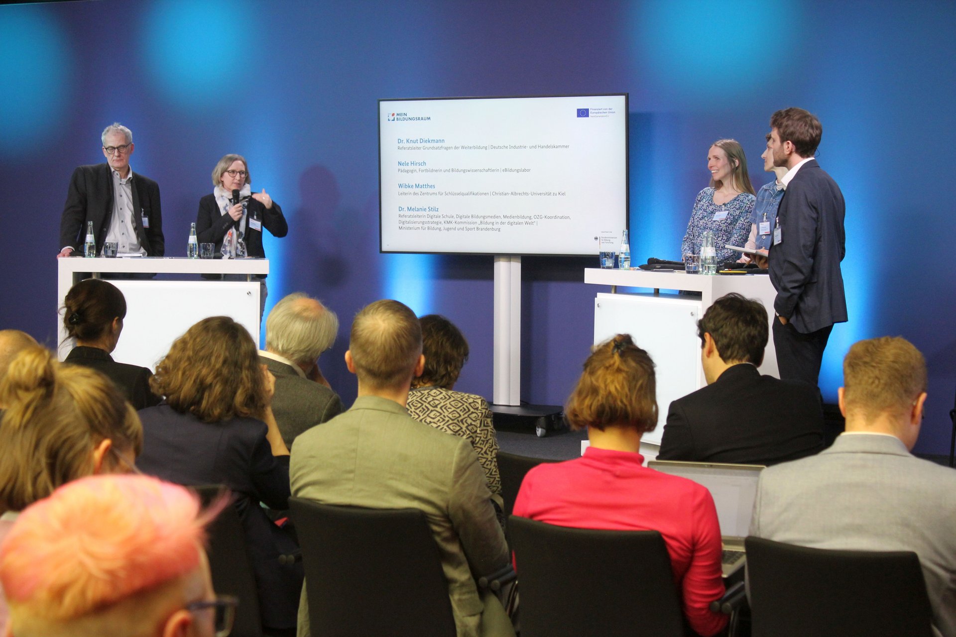 Teilnehmende der Podiumsdiskussion auf der Bühne