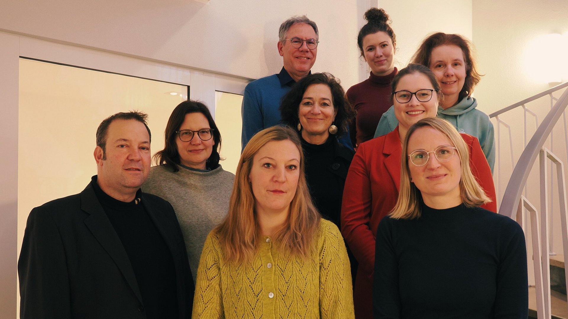 Das Foto zeigt neun Mitarbeitende des KUCOBINA-Verbundprojektes auf einer Treppe stehend.